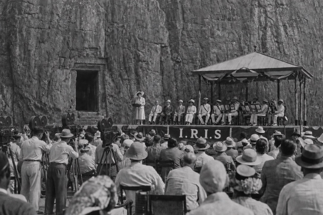 Black and white wide photograph of a crowd at the Lion Rock Chamber opening, with an I.R.I.S. banner above the platform.